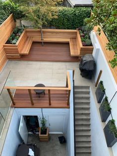 an overhead view of a patio with wooden benches and planters on the side walk