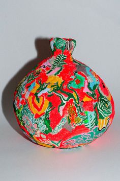 a colorful vase sitting on top of a white table