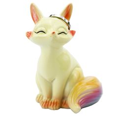 a small ceramic cat figurine sitting on top of a white surface with its eyes closed