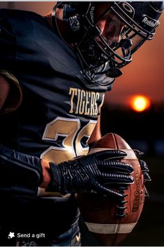 a football player holding a ball in his right hand with the sun setting behind him