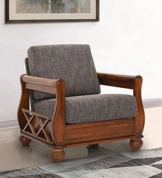 a chair sitting on top of a rug next to a wall with a painting above it