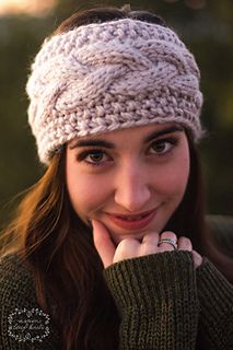 a woman wearing a knitted headband with her hands on her chin and looking at the camera