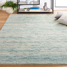 an area rug in the middle of a living room with pillows on top of it