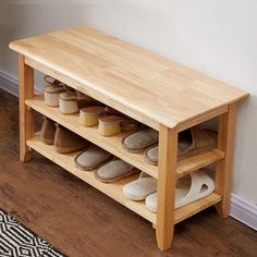 a wooden shoe rack with several pairs of slippers on the top and bottom shelf