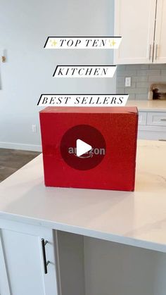 a red box sitting on top of a kitchen counter next to a white cabinet with the words top ten, kitchen best sellers