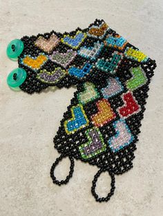 "This cuff-style bracelet is made of size 11/0 seed beads, opaque black with hearts in various colors.  Closure is 2 small buttons (green) and bead loops. Bracelet is 1 3/4\" wide. Size: 6 3/4\" (band is 6 1/4\", clasp adds 1/2\".) I recommend measuring your wrist and adding 1/2\" for best fit." Adjustable Black Heart Bracelet, Adjustable Green Heart-shaped Beaded Bracelets, Black Heart Beads Bracelet, Black Beaded Bracelets With Heart Beads For Gifts, Black Beaded Bracelets With Heart Beads As Gift, Black Beaded Heart Bracelets With Heart Beads, Black Beaded Bracelets With Heart Beads, Handmade Green Heart Beaded Bracelets, Handmade Green Heart-shaped Beaded Bracelets