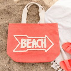 You'll be beach ready with the Aruba Water Resistant Tote! Water resistant so your belongings won't get wet, this tote bag features a vibrant coral color with the word 'Beach' hand embroidered across the front and inner pockets inside for extra organization, this water resistant bag will be your new summertime staple. This beach bag effortlessly doubles as a cruise bag, sports bag, or overnight bag to store your travel essentials. The perfect vacation bag or "weekend vibes'' bag! This reusable t Sand Colored Tote Beach Bag, Sand-colored Tote Beach Bag For Beach Season, Sand-colored Tote Beach Bag, Pink Canvas Bag For Beach Travel, Casual Embroidered Beach Bag For Vacation, Embroidered Rectangular Canvas Beach Bag, Weekend Tote Beach Bag For Beach Season, Beachy Bags For Weekend Beach Season, Weekend Beach Tote Bag For Beach Season