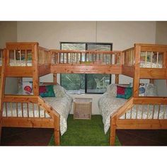 three wooden bunk beds sitting next to each other on top of a green carpeted floor