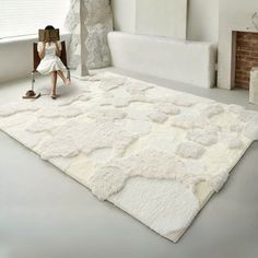 a woman sitting on top of a white rug