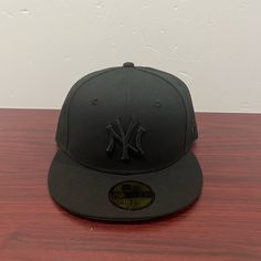 a new york yankees hat sitting on top of a wooden table