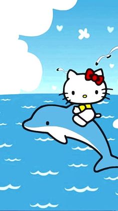 a hello kitty riding on top of a dolphin in the ocean with a heart shaped bow