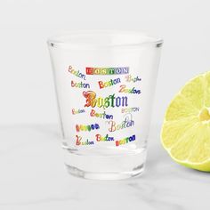 a shot glass with the word boston on it next to a lemon