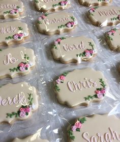 decorated cookies in plastic wrappers with names and flowers on them, sitting on a table