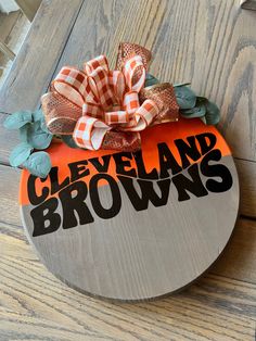 an orange and black sign with the words cleveland browns on it sitting on top of a wooden table