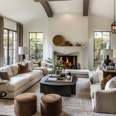 a living room filled with furniture and a fire place in the middle of two walls