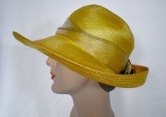 A vintage 1980s saffron yellow woven straw cloche style sun hat with an antique gold wide ribbon band and a pale copper silk rose with metallic gold edges.  The hat was made in USA by Plaza  suite by Betmar.  The hat has a 1/2 inch rip at the back of the crown and a 1 inch green mark on the inner band.  The brim is 4 inches wide at the front, the crown is 4 inches tall, 7 inches front to back and 6 inches side to side measured across the top, 24 inches around the inner gros grain band.  7 oz., boxed Please also follow me on Instagram at ChrisMartinDesigns Gold Wide-brim Straw Hat For Kentucky Derby, Gold Fedora Straw Hat For Summer, Gold Brimmed Straw Hat For Kentucky Derby, Gold Fedora For Kentucky Derby, Gold Wide Brim Straw Hat For Kentucky Derby, Gold Wide Brim Straw Hat, Gold Wide-brim Hat For Party, Gold Wide Brim Hat For Party, Fitted Gold Summer Hat