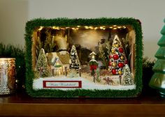 a christmas scene is displayed on a mantle