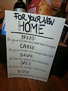 a sign that says for your own home bread and wine are on the table next to a bottle of wine