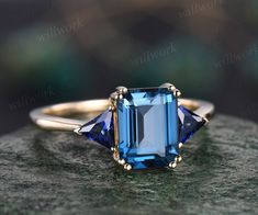 This ring is handmade by myself. The main stone is a 6x8mm emerald cut natural London blue topaz. The accent stones are Trillion cut 3.5mm lab sapphires. The band width is about 1.4mm. The material is solid 14k gold(white,yellow,rose gold is also available) Ring size can be choose from the selection box. This jewelry can also be made in solid 10k,14k,18k gold,with real diamonds.Contact me! Need rush order? contact me! Need custom making order? Contact me! I have confidence on my jewelry.30 days money back guarantee!(For returned item,as this is handmade jewelry.Handcrafted fee and shipping fee will be deducted,others will be refunded soon) Thanks for your visiting! Emerald Cut Three Stone Birthstone Ring For Formal Occasions, Formal Three-stone Emerald-cut Birthstone Ring, Formal Three Stone Emerald Cut Birthstone Ring, Formal Emerald Cut Three Stone Birthstone Ring, Sapphire Birthstone Ring With Emerald Cut And Accent Stones, Trillion Cut Topaz Jewelry For Anniversary, Sapphire Emerald Cut Birthstone Ring With Accent Stones, Emerald Cut Sapphire Ring Gift, Sapphire Birthstone Ring With Emerald Cut