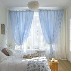 a white bed sitting under a window in a bedroom