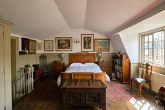 an old fashioned bedroom with wooden furniture and pictures on the wall