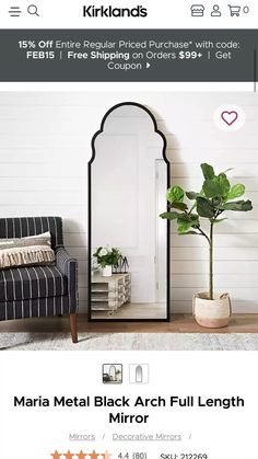 a living room with a chair, mirror and potted plant