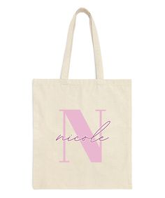 a pink tote bag with the letter n in cursive writing on it