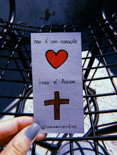 someone holding up a card with a cross and heart on it