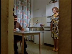 a man and woman sitting at a kitchen table