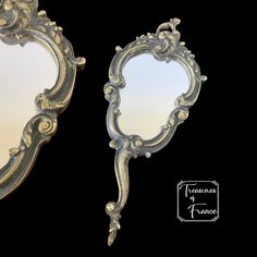 two mirrors with ornate designs on them against a black background