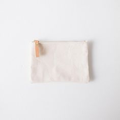 The zip pouch is handmade of heavyweight cotton canvas, with a solid brass zipper that features a leather pull for easy use. It's the perfect accessory to organize items in your tote or to carry on its own. The small zip pouch measures 5.5 inches by 7.5 inches, and the medium zip pouch measures 7 inches by 9.5 inches. Everyday Canvas Pouch With Zipper Closure, Cotton Pouch With Zipper For Everyday Use, Cotton Pouch With Zipper Closure For Everyday Use, Travel Cotton Zipper Pouch, Cotton Travel Pouch, Everyday Canvas Cosmetic Bag With Zipper Closure, Minimalist Rectangular Pouch With Zipper, Minimalist Rectangular Zipper Pouch, Canvas Pouch For Everyday Use