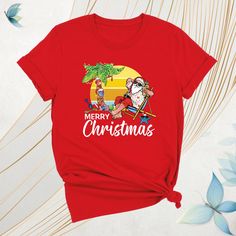 Mele Kalikimaka Christmas Shirt, Merry Hawaiian Santa Christmas Shirt, Beach Xmas Team Tee, Tropical Christmas Shirt, Coastal Party Xmas Tee Celebrate the season island-style with our Mele Kalikimaka Christmas Shirt! This festive Merry Hawaiian Santa Christmas Shirt brings tropical vibes to your holidays. Perfect for a Beach Xmas Team Tee or a fun Tropical Christmas Shirt at your next coastal party. Whether you're looking for a Santa Christmas Tee or a unique Coastal Party Xmas Tee, this Kalikimaka Christmas Shirt adds a Hawaiian twist to your Christmas celebrations. Ideal for holiday gatherings, this Island Christmas Tee is your go-to Christmas Party Tee for 2024! Mele Kalikimaka Christmas Shirt: How To Order: - Please, check all tees color and  size charts. - Select your shirt size, colo Christmas Holiday T-shirt With Short Sleeves, Christmas Holiday Short Sleeve T-shirt, Christmas Holiday Shirt With Graphic Print, Christmas Holiday Graphic T-shirt, Christmas Holiday Graphic Print T-shirt, Christmas Graphic Print T-shirt, Christmas Holiday Graphic Print Shirt, Christmas Graphic Tee Shirt For Holiday, Red Christmas Shirt For Holiday