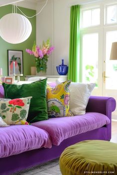 a living room filled with purple couches and pillows