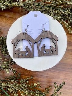 the wooden earrings are designed to look like they have been cut out from wood and decorated with animals