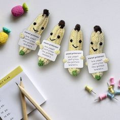 three crocheted banana brooches with funny faces and words written on them