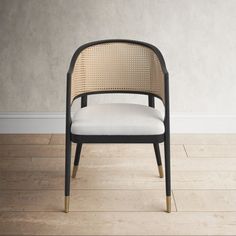 a black and white chair sitting on top of a hard wood floor next to a wall