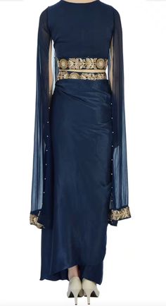 Saree is pre-stitched Saree is pre-pleated Saree is pre-made Stunning navy blue saree that has a pleated maxi skirt with floral motif work paired with cape-style cropped blouse. This set comes with sequin embellished drape! The fabric is modal satin and georgette.