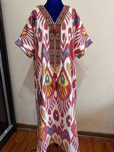 This dress is made of cotton ikat fabric.In Uzbek tradition, women sewed dressed from  these fabrics and wore this type  of dresses to weddings.By this time,girls and women are wearing dresses from vintage loving. Care;dry cleaning only. Length;125cm  / 49inches. Sleeve:37cm  /14,5inches. Chest:134cm/53inches. Size:Oversize. Every item will be shipped from Uzbekistan via postal service. Tracking number will be provided. PROCESSING TIME; 1-2 WORK DAYS. SHIPPING TIME; 2-4 WEEKS. SHIPPING COST; $25 for 1set. $15 for each additional item. Red Bohemian Kaftan With Ikat Print, Traditional White Ikat Print Dress, Traditional White Dress With Ikat Print, Traditional Ikat Print Tunic Dress, Traditional Ikat Print Maxi Kaftan, Traditional Maxi Kaftan With Ikat Print, Bohemian Maxi Dress For Traditional Ceremonies, Traditional Ikat Print Tunic Kaftan, Traditional Ikat Print Patterned Dress