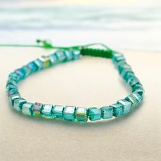 a close up of a beaded bracelet on the beach