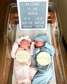 two baby babies are laying next to each other in a glass box with a welcome sign