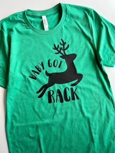 Baby Got Rack!! Black design printed on a green or red tee. Super soft!! Comfy, unisex fit so I suggest going down a size if you like a more fitted look.  Check out the rest of our Rad Christmas designs!! 🎄 Snarky Christmas Shirts, Festive Green Casual Tops, Green Cotton Holiday Top, Green Cotton Top For Holidays, Festive Green Short Sleeve Top, Casual Green Top For Holiday, Casual Green Holiday Tops, Green Short Sleeve Top For Holiday, Green Short Sleeve Holiday Top