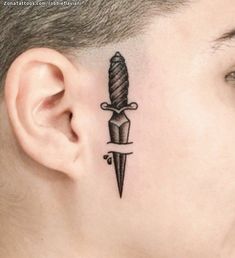 a man with a tattoo on his neck and behind the ear has a knife in it