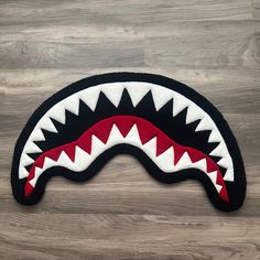 a black and white rug with a red shark's teeth on the front side