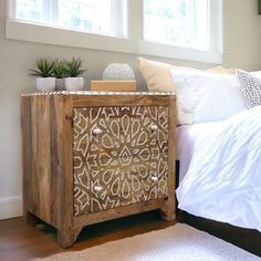 a bed room with a neatly made bed and a wooden dresser next to a window