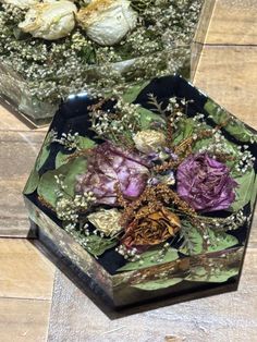 two glass vases with flowers in them on a table