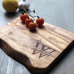 a cutting board with tomatoes on it next to some garlic and lemons in the background