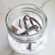 a glass jar filled with seaweed and salt on top of a white countertop