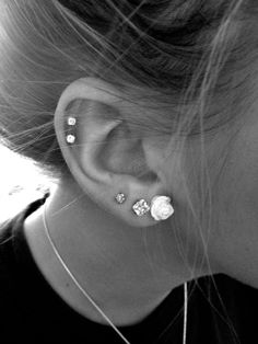 a close up of a person's ear with three different piercings on it