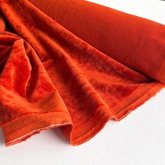 an orange blanket laying on top of a white table