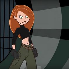 a woman with red hair and green pants standing in front of a caged area